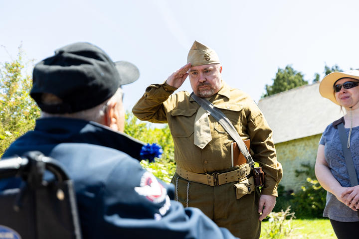 Walter Ruf salutes World War II Army veteran Andy Negra. Walter drove 11 hours to Normandy from Germany to thank a veteran for liberating his homeland and saving his mother, who faced execution under Nazi rule due to a heart condition.